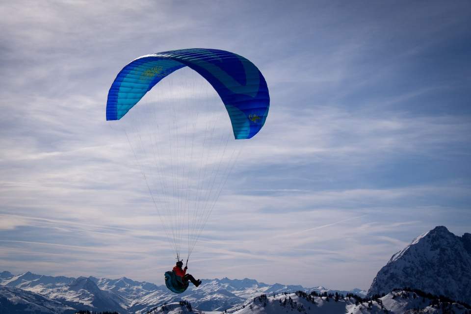 parapente au-dessus des montagnes enneigées